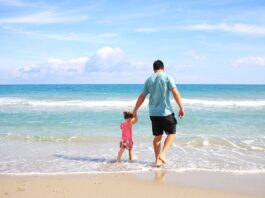 dad-walking-with-his-child-in-the-seashore