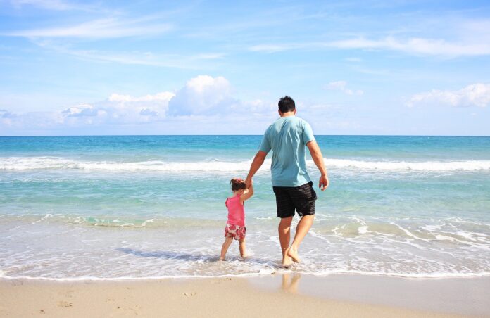 dad-walking-with-his-child-in-the-seashore