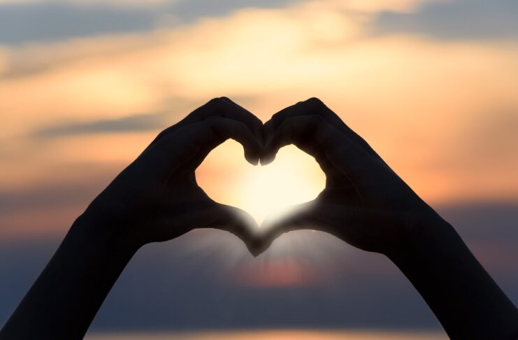 heart-shape-with-hands-cloudy-sky