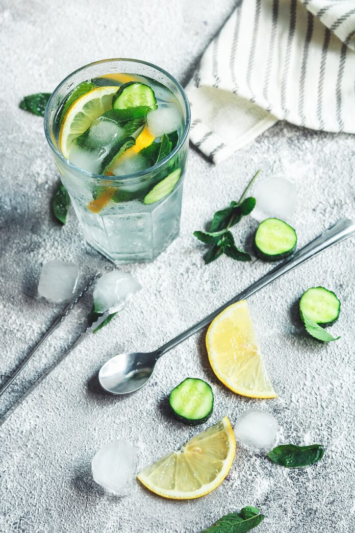 lemonade-with-lemon-water-cucumber-and-spoon-in-a-glass